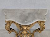 a marble topped table with a gold leaf design on it