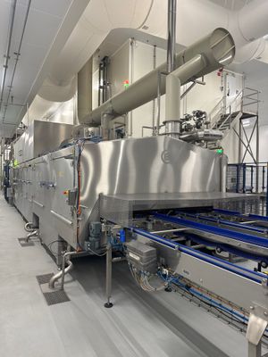 une photo d'une usine avec un tapis roulant et un tapis roulant