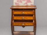 a small wooden table with a drawer and a painting on it