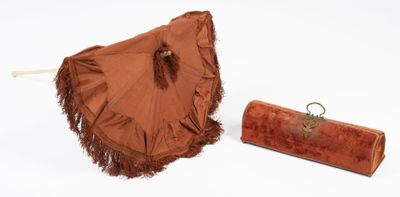 a brown umbrella and a brown purse on a white surface