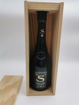 la bouteille de vin se trouve dans une caisse en bois, à côté d'un morceau de bois