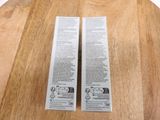 two boxes of toothpaste sitting on a wooden table