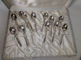 six silver spoons in a box on a table