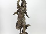 bronze statue of a woman holding a bird on her head