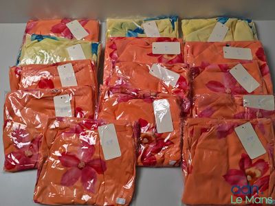 plusieurs sacs contenant des vêtements orange et jaunes, avec leurs étiquettes de prix