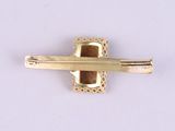 a gold tie bar with a cross on it