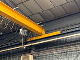 a large yellow crane hanging from the ceiling of a building