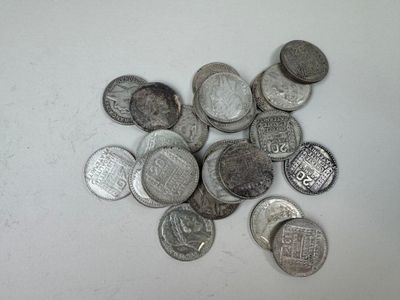 une pile de pièces d'argent posée sur une surface blanche