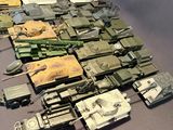 a lot of toy army vehicles and tanks on a table