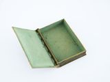 a small green box that is open on a white surface