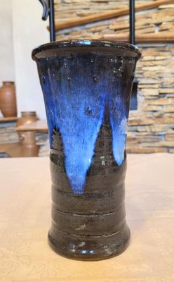 un vase bleu et noir posé sur une table