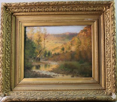 une peinture à l'huile représentant une rivière, dans un cadre doré, accrochée à un mur bleu