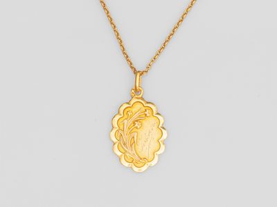 un collier plaqué or avec un pendentif en forme de fleur au bout d'une chaîne