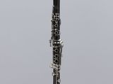 a close up of a clarinet on a stand with a gray background