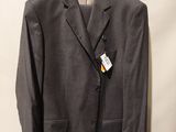 gray suit jacket hanging on a hanger on a white wall