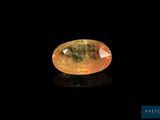 a yellow sapphire stone on a black surface
