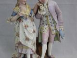 une figurine représentant deux personnes debout l'une à côté de l'autre