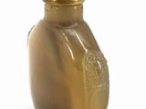 a brown bottle with an orange cap sitting on a white surface