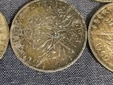 four different types of coins sitting on top of a blue cloth