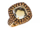 un gros plan d'une bague ornée d'une grosse pierre entourée de cristaux bruns