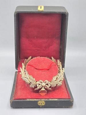 une couronne en or dans un coffret rouge sur fond blanc