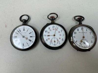 trois types différents de montres de poche exposées sur une table