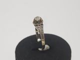 an image of a diamond ring on a black stand on a white surface