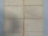 an old piece of paper with writing on it sitting on top of a table