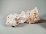 crystal on a white surface with a small piece of rock in the background