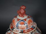 an image of a red and blue vase with a bird on top