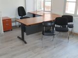 une photo représentant un bureau et des chaises dans une pièce