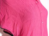 the shirt is pink and has a black stripe on the collar
