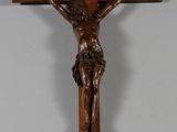 crucifix en bois représentant Jésus sur la croix, accroché à un mur blanc