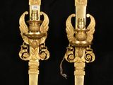 pair of antique brass wall sconces on black background