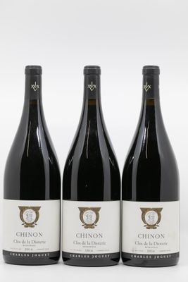 trois bouteilles de vin rouge posées sur une table blanche