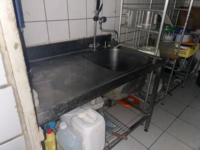 a kitchen with a sink and a metal shelf