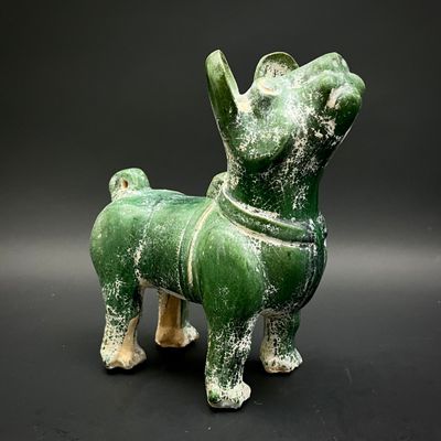 a green statue of a dog on a black background