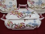 four plates and a casserole on a red table