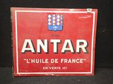 une vieille enseigne rouge et blanche sur laquelle est inscrit « antar »