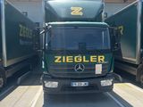 a green truck that is parked in a parking lot
