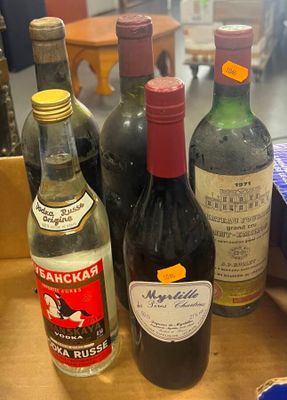 Plusieurs bouteilles de vin sont posées sur une table dans une pièce.