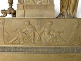a gold statue of a woman and a man sitting on a bench