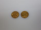 Deux pièces d'or sont représentées sur une surface blanche