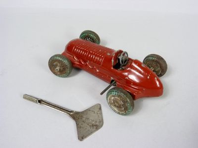 une petite voiture rouge avec une pelle à côté