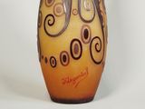 a vase with swirly designs on it sitting on a table