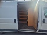 a white van with a wooden door open in a parking lot