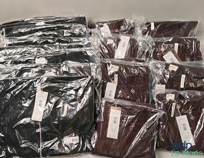 many bags of clothing sitting on a shelf next to each other
