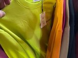 a lot of shirts hanging on a rack in a store