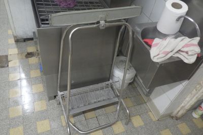 a metal cart that is next to a trash can