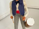a figurine of a man with a hat and vest holding a drum